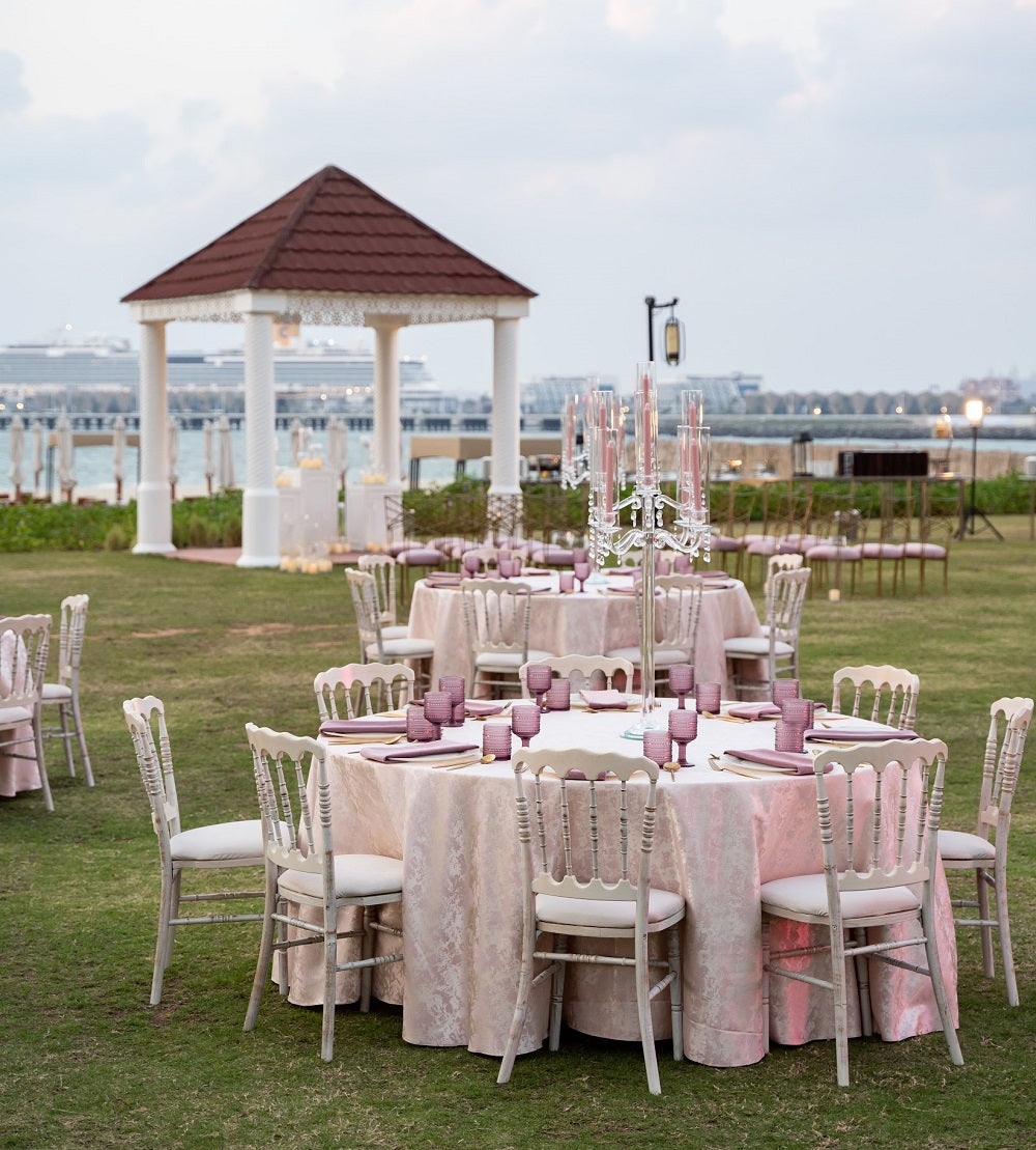 NAPOLEON CREAMWASH CHAIR set up outdoors for a party, showcasing its simple, rustic design amidst a table setting for weddings or events.