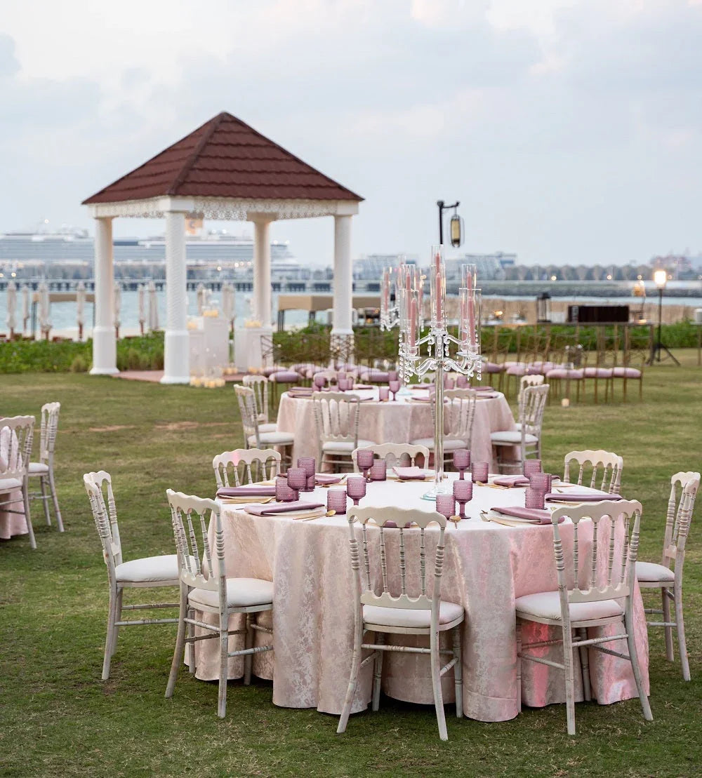 NAPOLEON CREAMWASH CHAIR set up outdoors for a party, showcasing its simple, rustic design amidst a table setting for weddings or events.