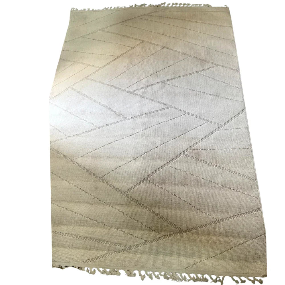 RUG ABSTRACT NATURAL WOVEN: Flat-woven area rug with a subtle geometric pattern and fringed edge, perfect for adding a natural, refined touch to event spaces.