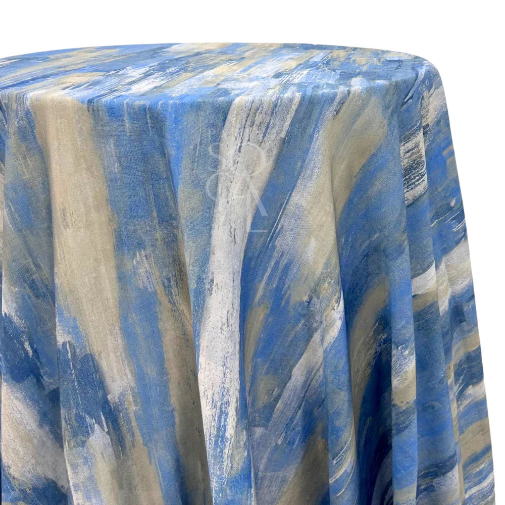 BLUE BRUSHED ROUND TABLECLOTH elegantly drapes over a round table, showcasing its luxurious blue fabric with a sophisticated gold brushed pattern, perfect for upscale event décor.
