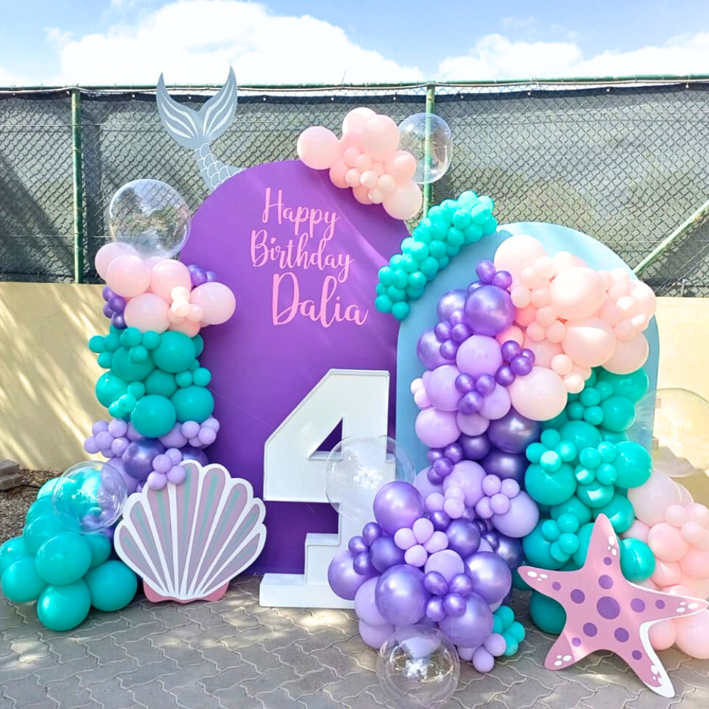 Mermaid-themed balloon arch with tail, starfish, and shell sign, perfect for ocean-inspired events. Part of Party Social’s Ocean Dream Balloon Backdrop.