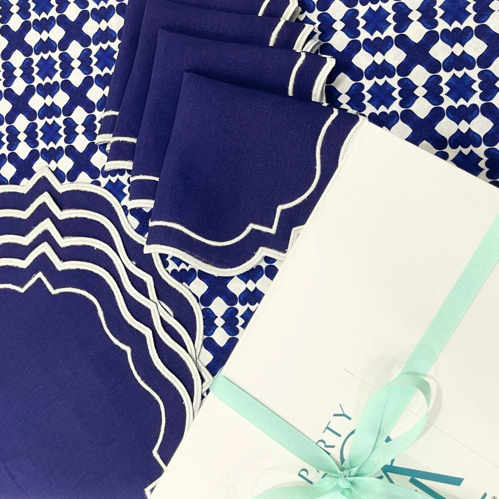 The Iftar Table Edit Gift Box featuring navy napkins, a patterned tablecloth, and a white gift box with aqua ribbon, perfect for Ramadan celebrations.
