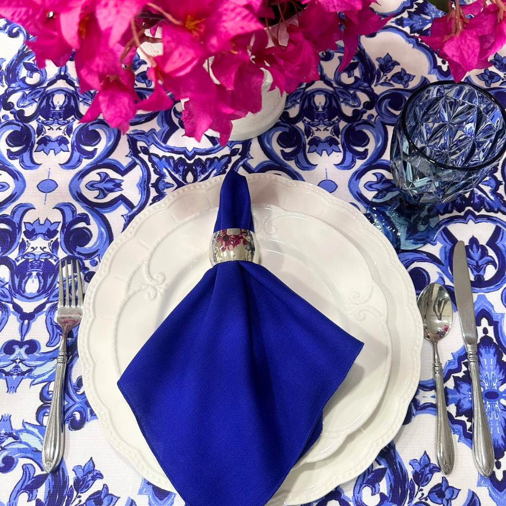 NAPKIN COTTON LINEN elegantly displayed on a plate with a silver fork and spoon, accompanied by a vase of pink flowers, ideal for event table settings.