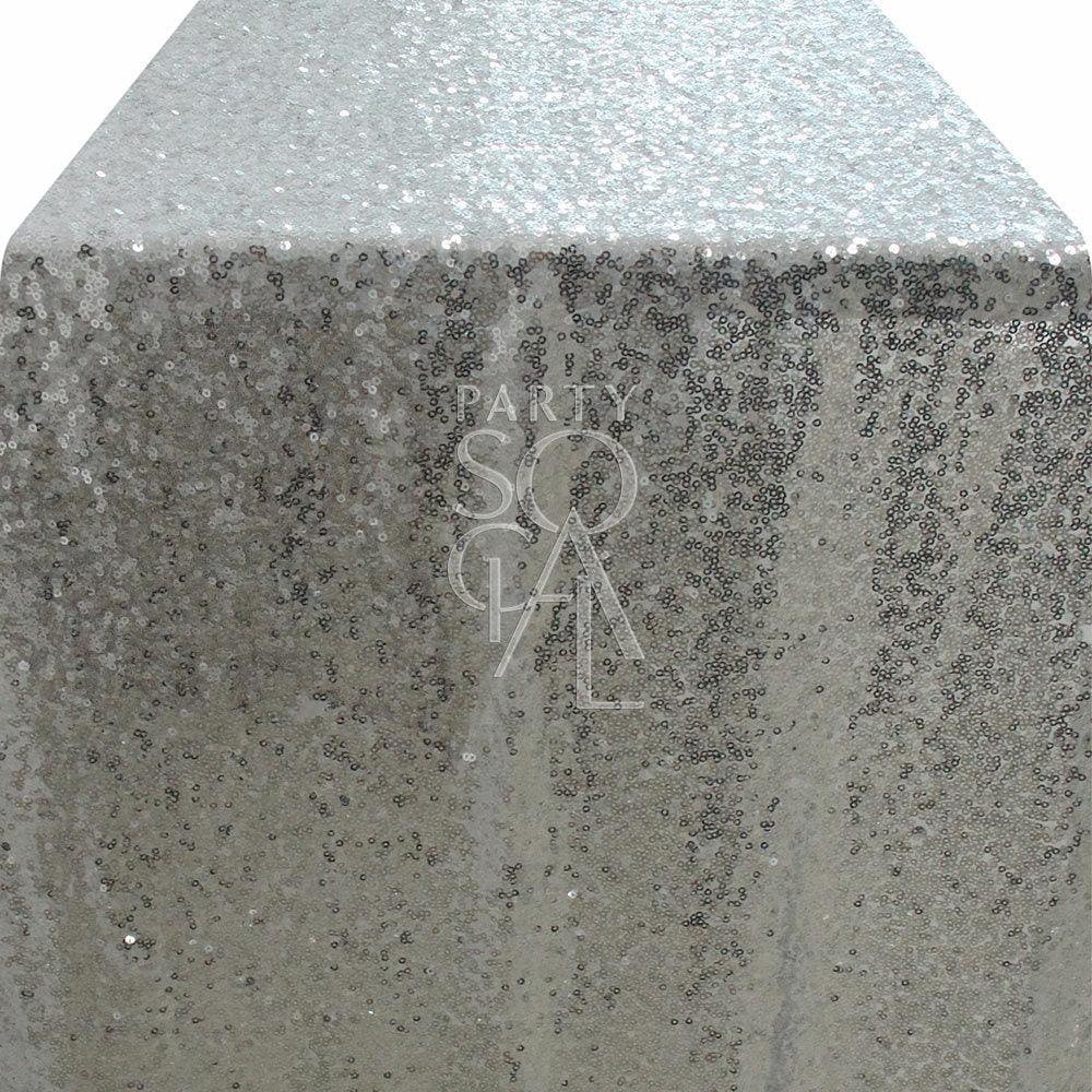 Silver sequin table runner, ideal for adding elegance to special occasions, reflecting light beautifully. Perfect for glamorous tabletops at parties and events.