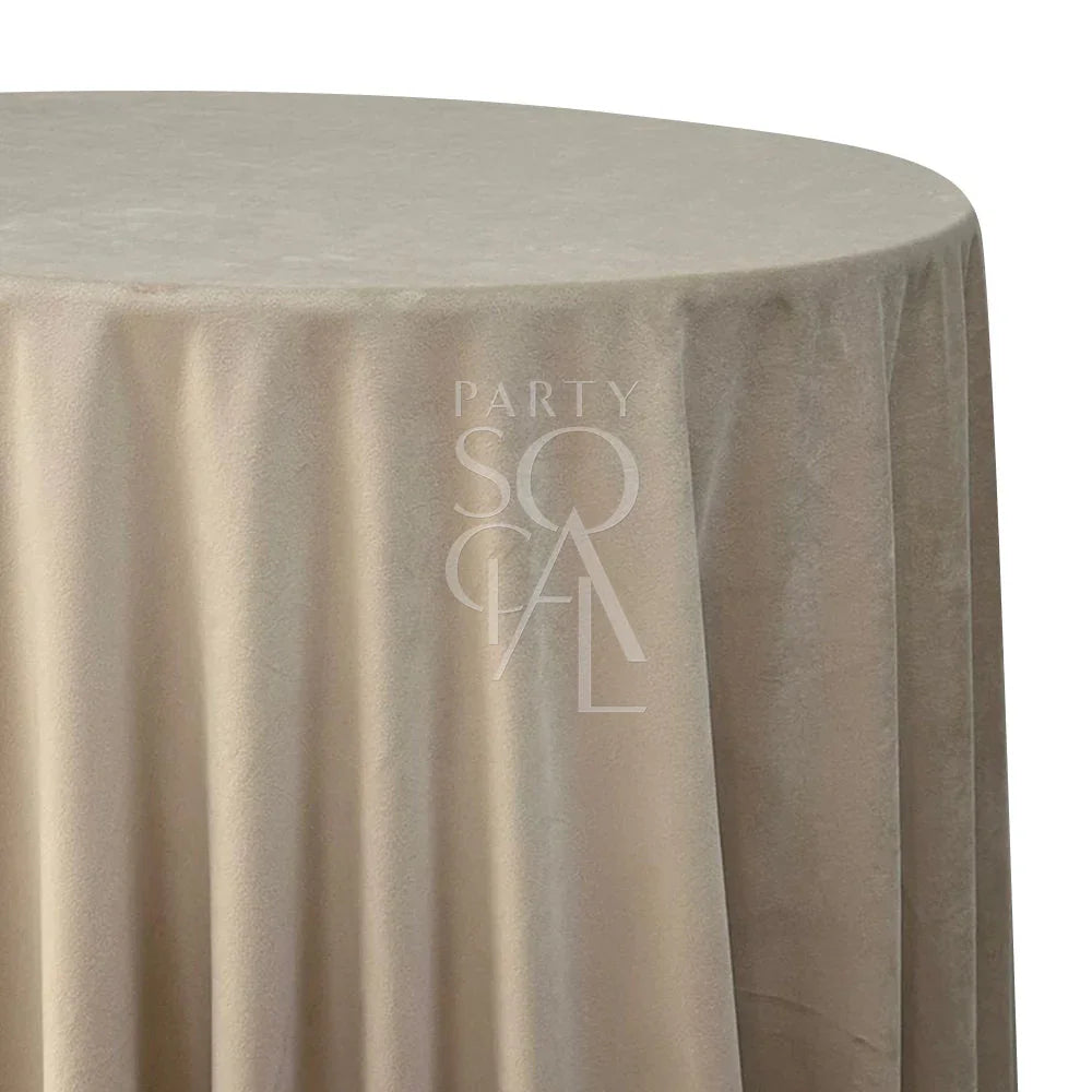 Round tablecloth velvet draped elegantly over a table, showcasing its luxurious texture. Ideal for enhancing special occasions, weddings, or dinner parties.