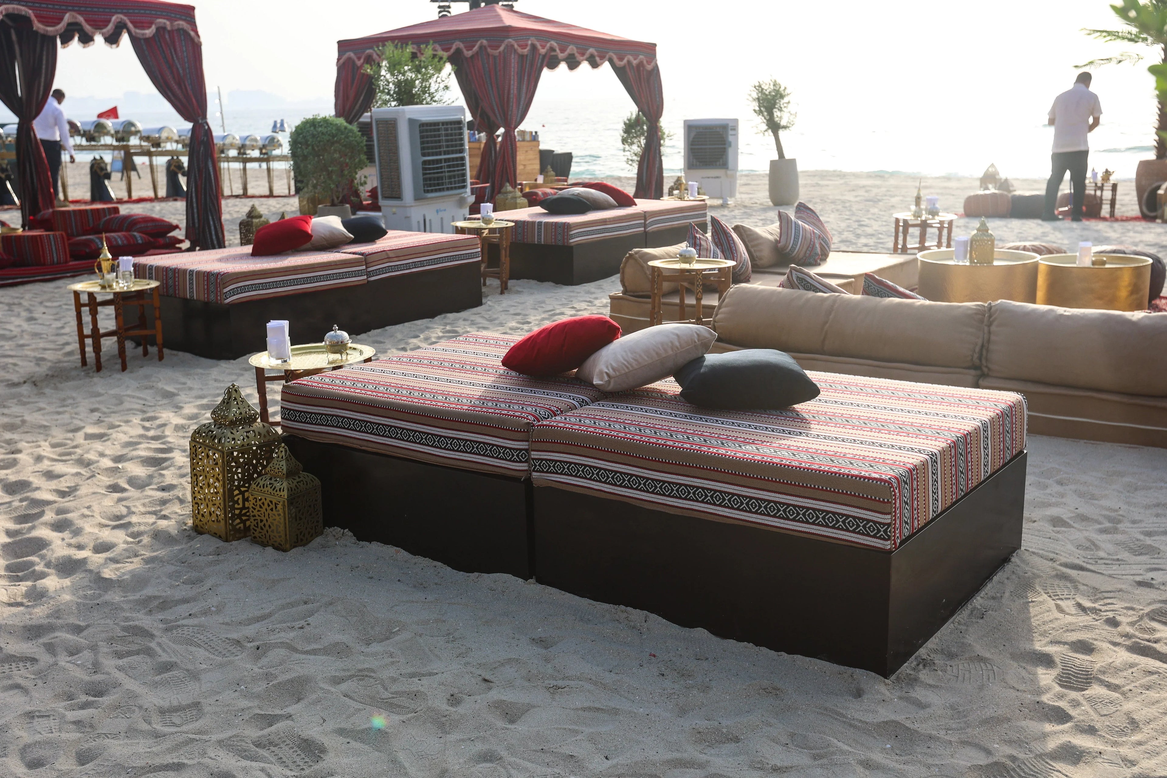 SOFA ISLAND on a beach, part of a modern lounge setup, ideal for events. Surrounded by pillows and decor, capturing a relaxed, stylish atmosphere.