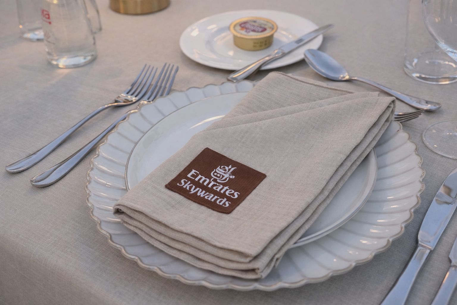 Table setting with Emirates Skywards branded napkin on a white plate.