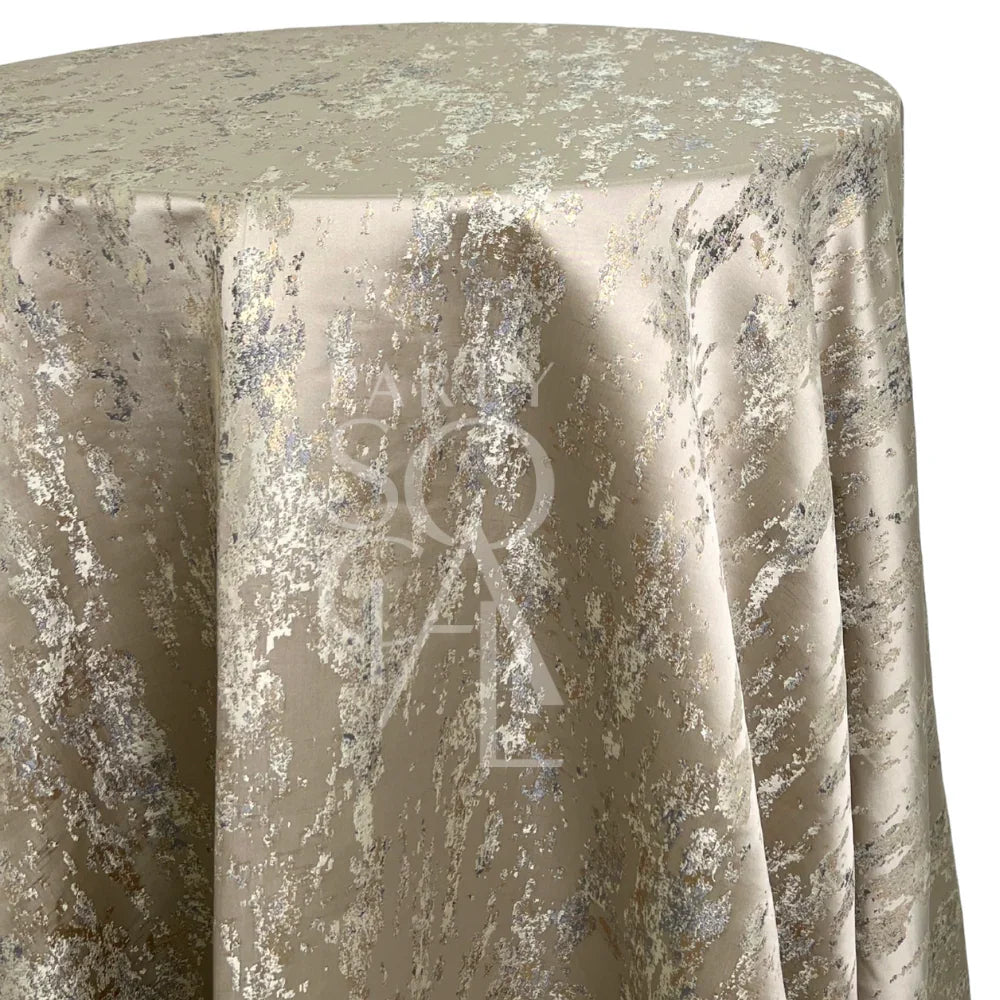 Champagne Distressed Metallic Round Tablecloth featuring silver and gold flecks on a silky base, ideal for contemporary or industrial-chic upscale events.