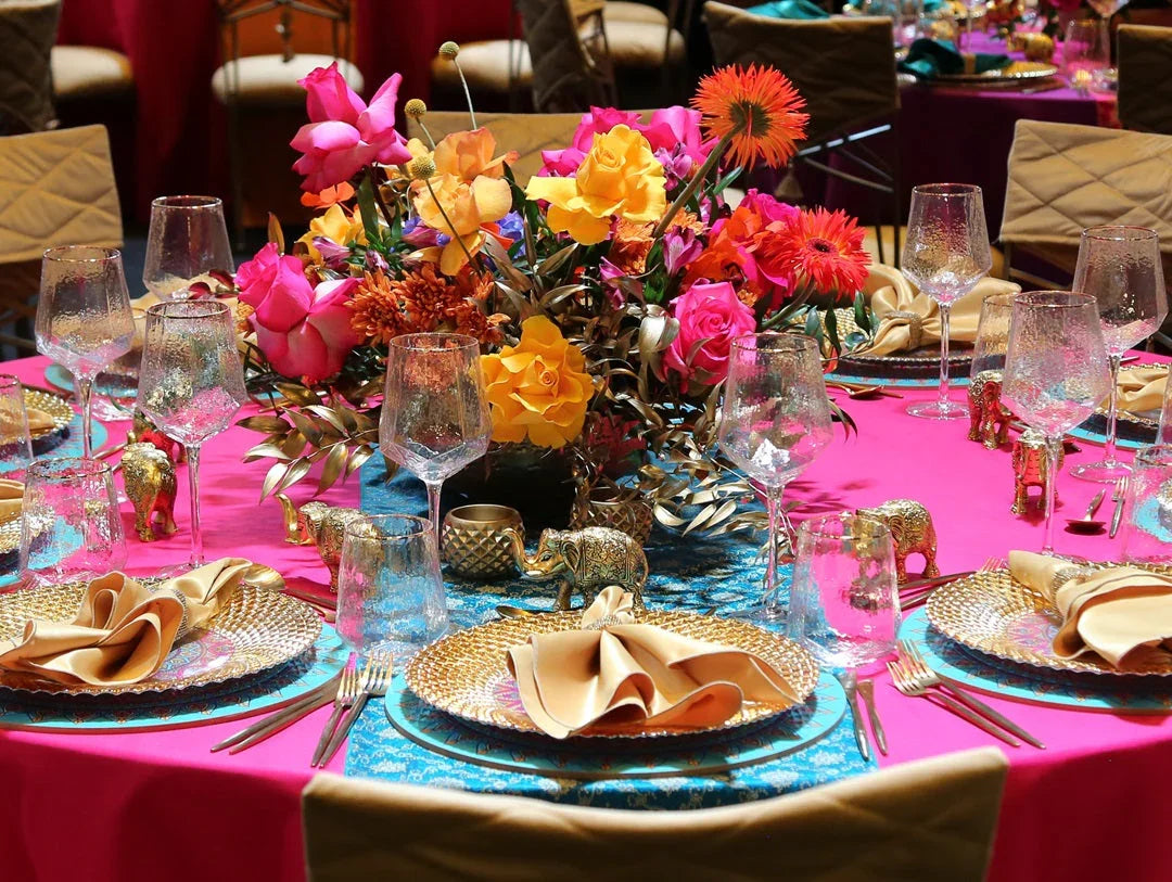 Brocade Table Runners adorn a dinner table set for an elegant gathering, featuring plates, wine glasses, and a stylish centerpiece.