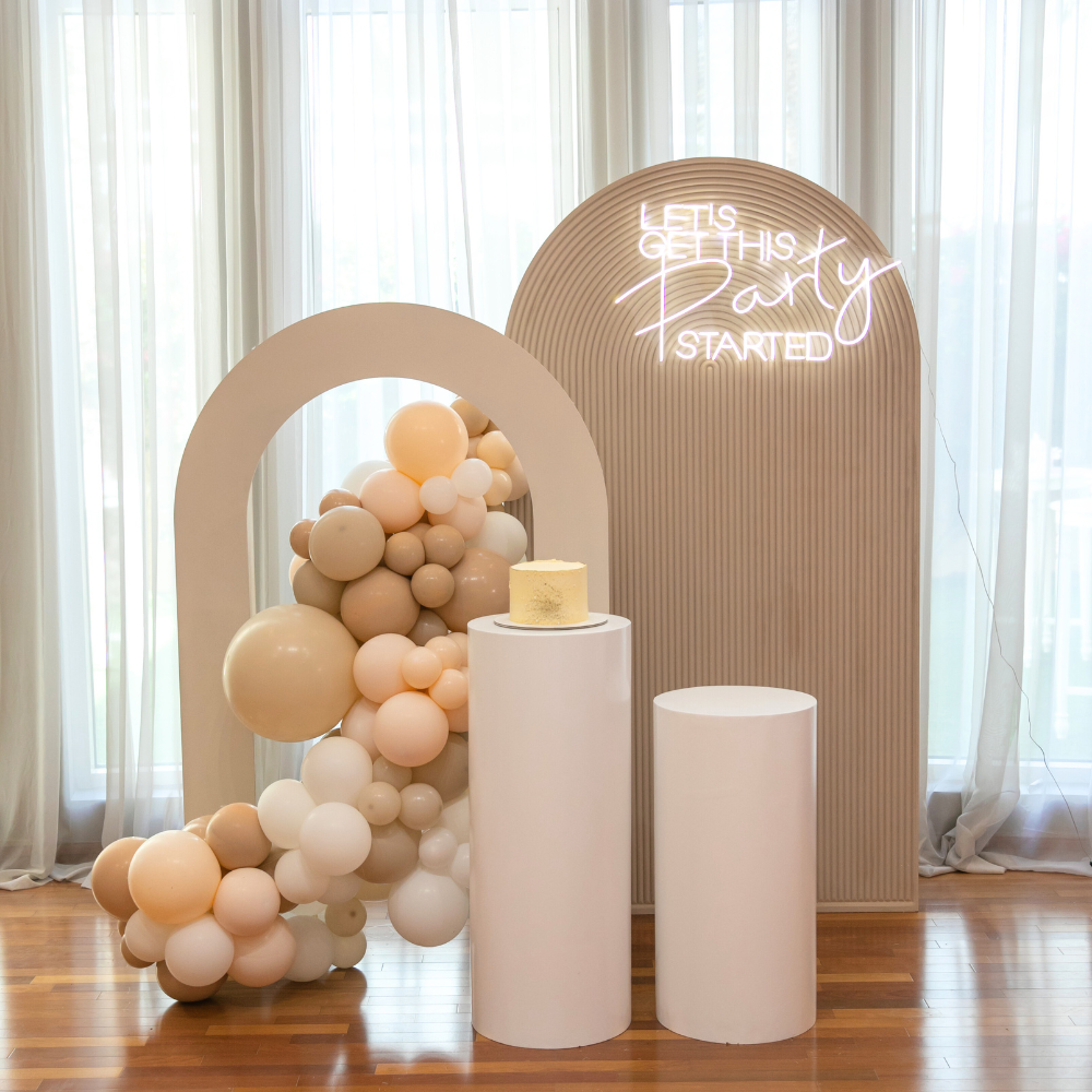 Boho & Woods Backdrop featuring a cake on a pedestal and balloon arch, perfect for enhancing party decor with a customizable, vibrant theme.