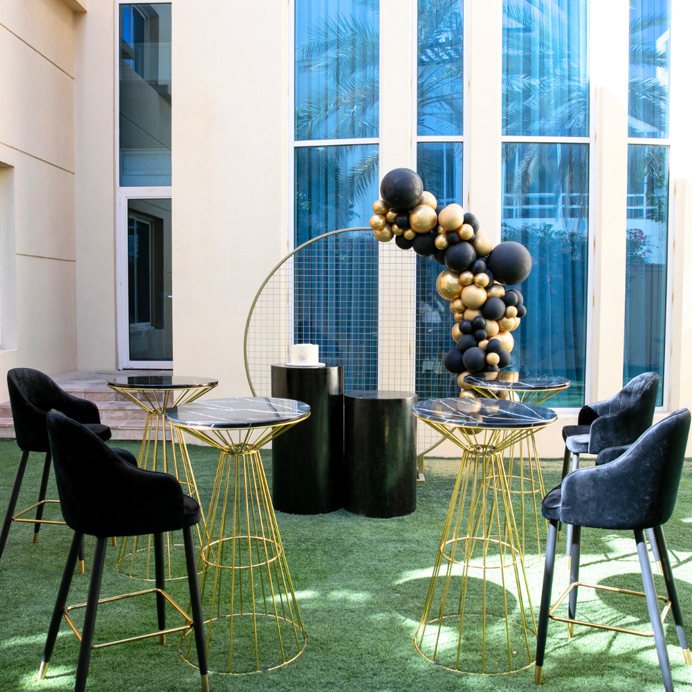 Black & Gold Backdrop displayed at an outdoor event setup with black chairs and tables, showcasing a customizable theme for parties and special occasions.
