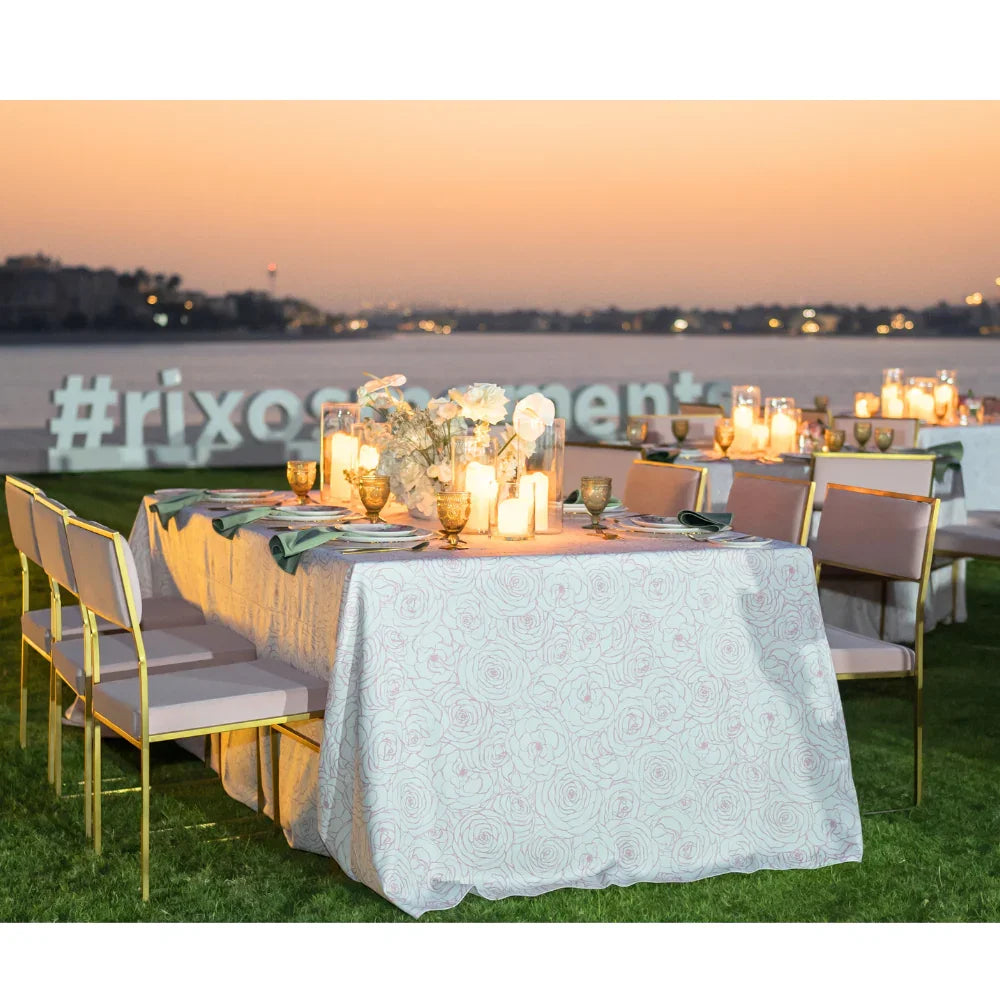 Pink Floral Rectangular Tablecloth on an elegantly set outdoor table with candles and flowers, ideal for enhancing any party or event dining setup.