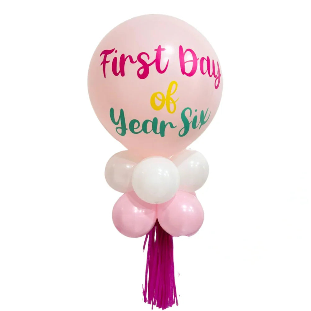 First Day of School Balloon Wand featuring a large pink balloon with custom writing, surrounded by smaller balloons, perfect for back-to-school celebrations.