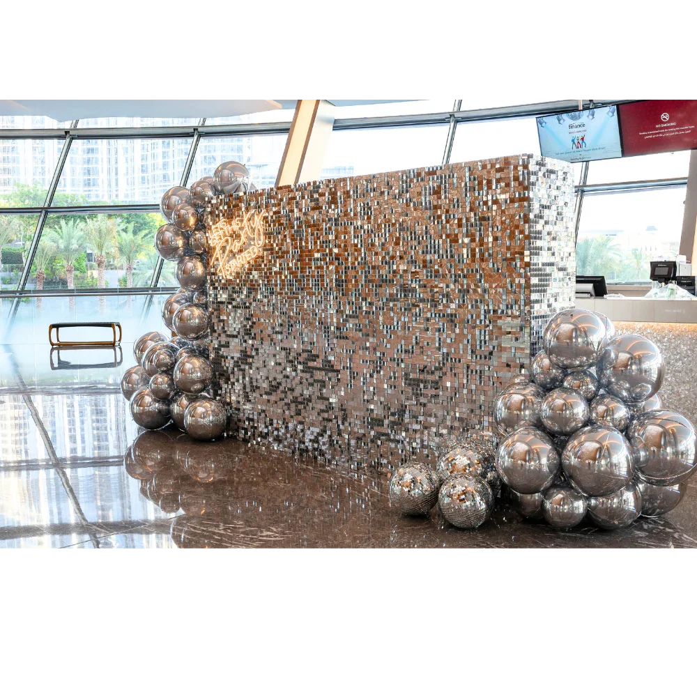 Silver Sequin Wall Balloon Backdrop with LED Neon Sign, featuring shiny silver balls, ideal for events like weddings and parties.