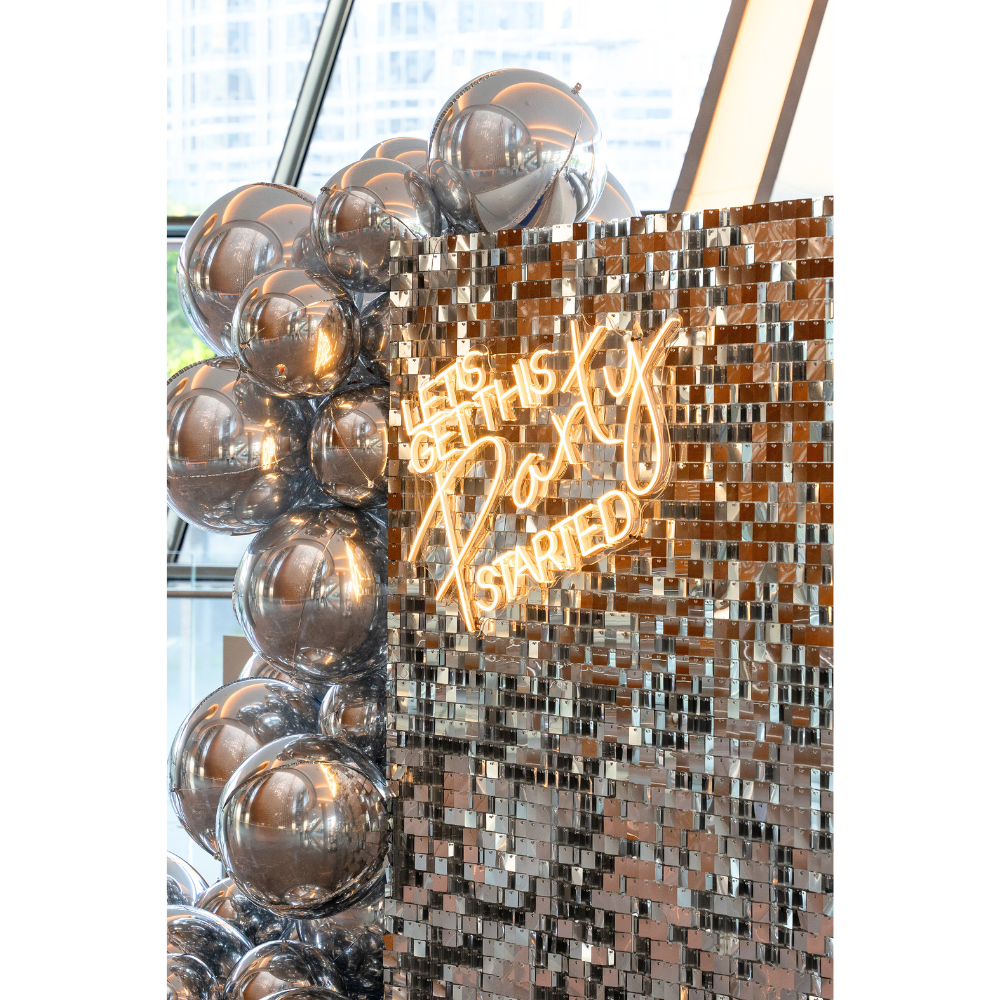 Silver Sequin Wall Balloon Backdrop with LED Neon Sign and silver balloons, ideal for weddings, birthdays, or special events.
