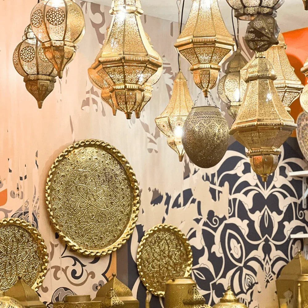 Round Moroccan Hanging Pendant lantern with intricate patterns, designed for candle lighting, showcased among a group of gold lanterns. Ideal for enhancing party atmospheres.