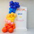 Angled Wall Balloon Backdrop for events, featuring various balloons next to a sign; ideal for celebrations like birthdays or showers, customizable for any occasion.