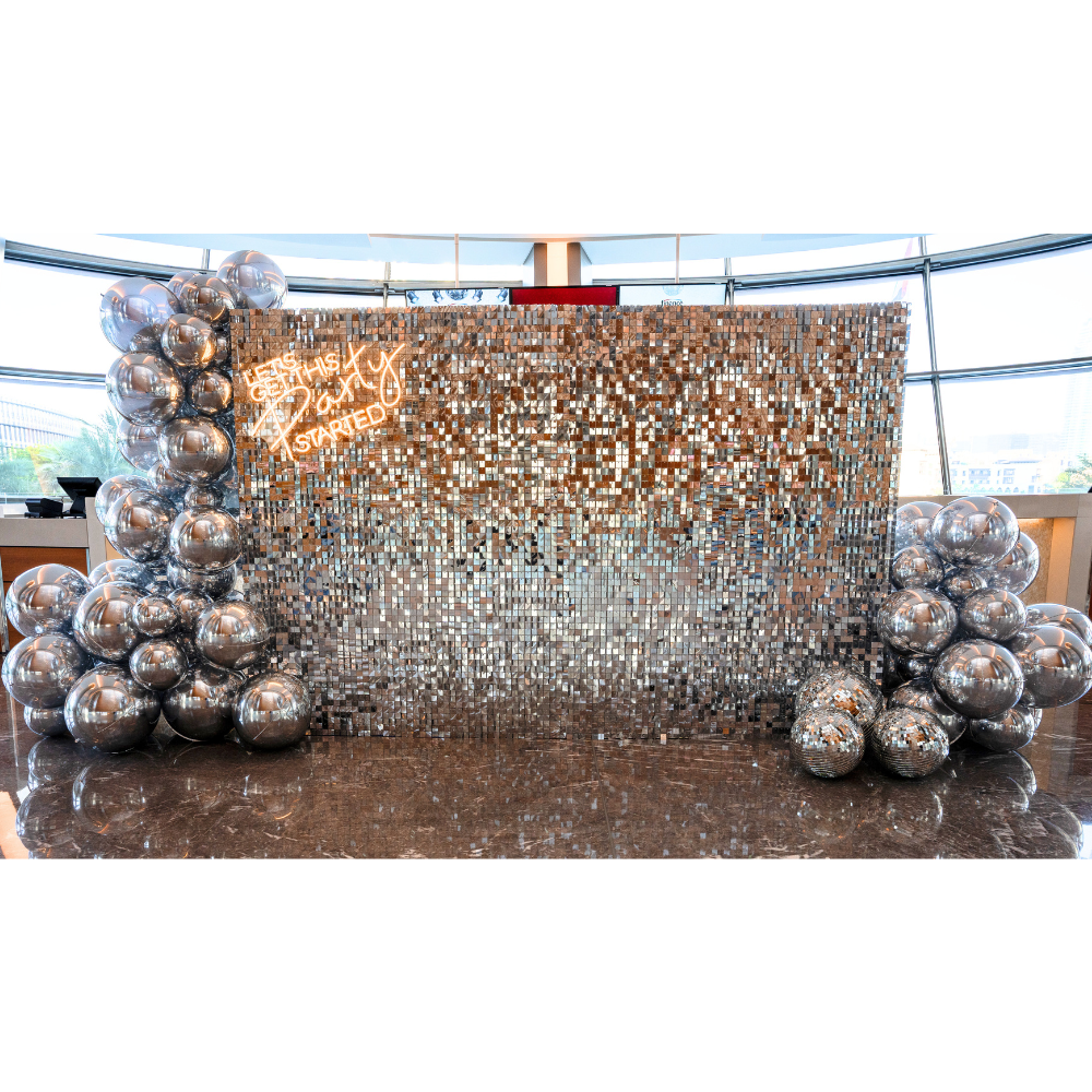Silver Sequin Wall Balloon Backdrop with LED Neon Sign, featuring silver balloon decorations; ideal for elegant events like weddings and parties.