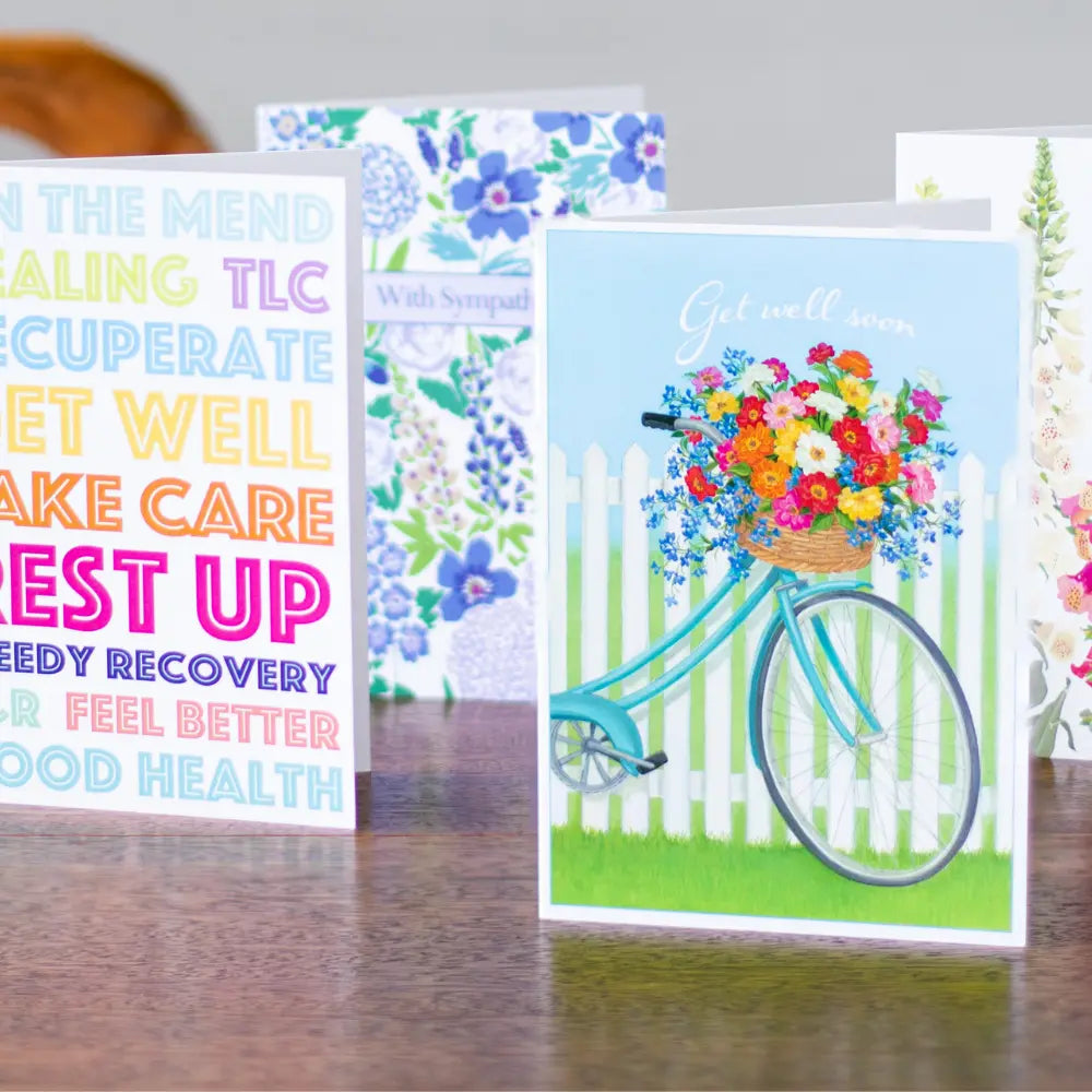 Collection of greeting cards with various designs on a wooden surface.