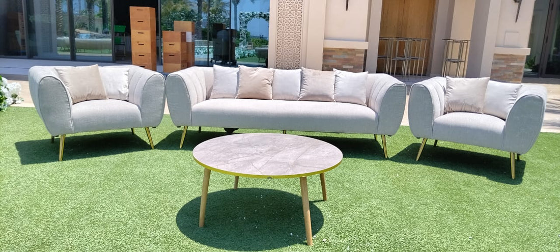 SAND TEXTURED SOFA SINGLE SEATER, ideal for outdoor lounge seating, featuring modern luxe design with pillows, situated on grass beside a table and chair.
