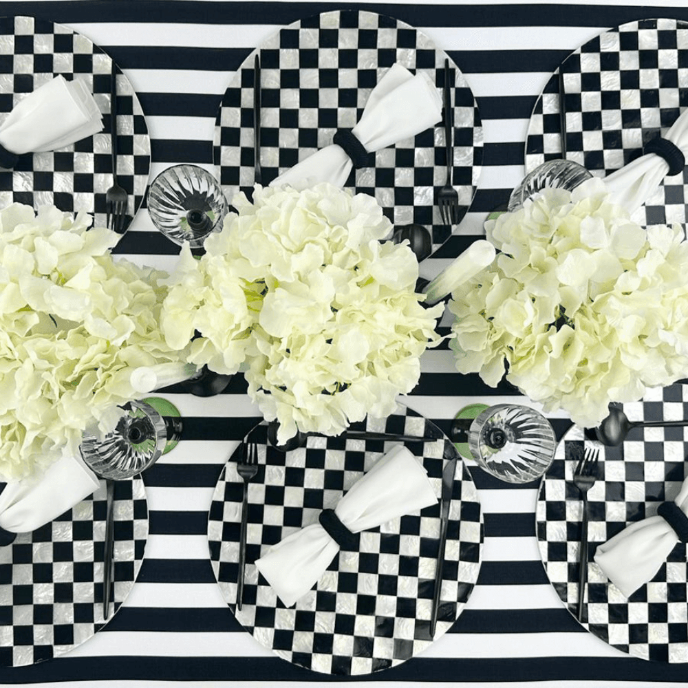 Black & White Linen Tablecloth on a set dining table with matching plates and white flowers.