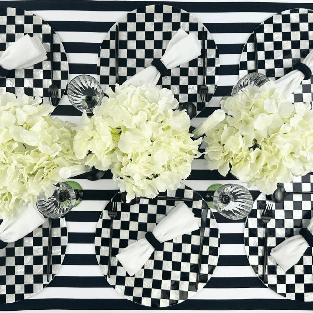 Black & White Linen Tablecloth on a set dining table with matching plates and white flowers.