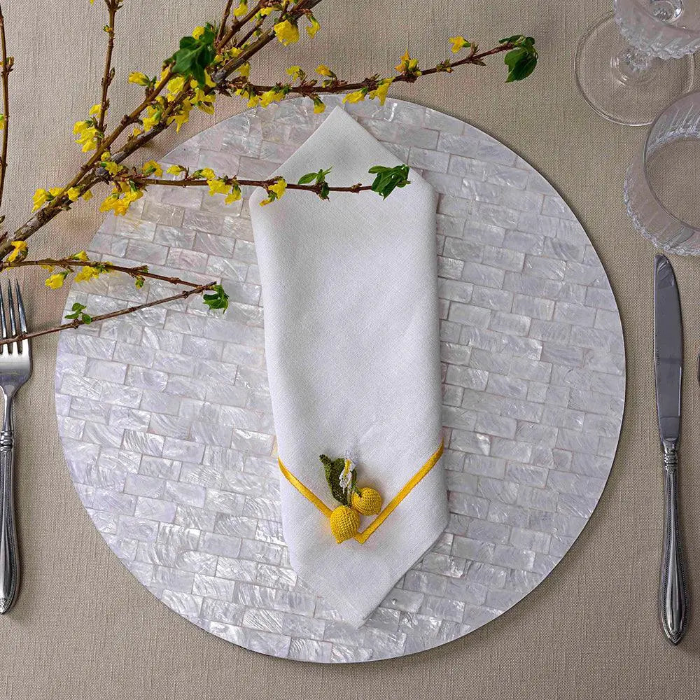 Yellow Lined Pure Linen Dinner Napkin - Set of 2, featuring yellow-trimmed white linen with crochet accents, elegantly displayed on a mosaic-style charger plate.