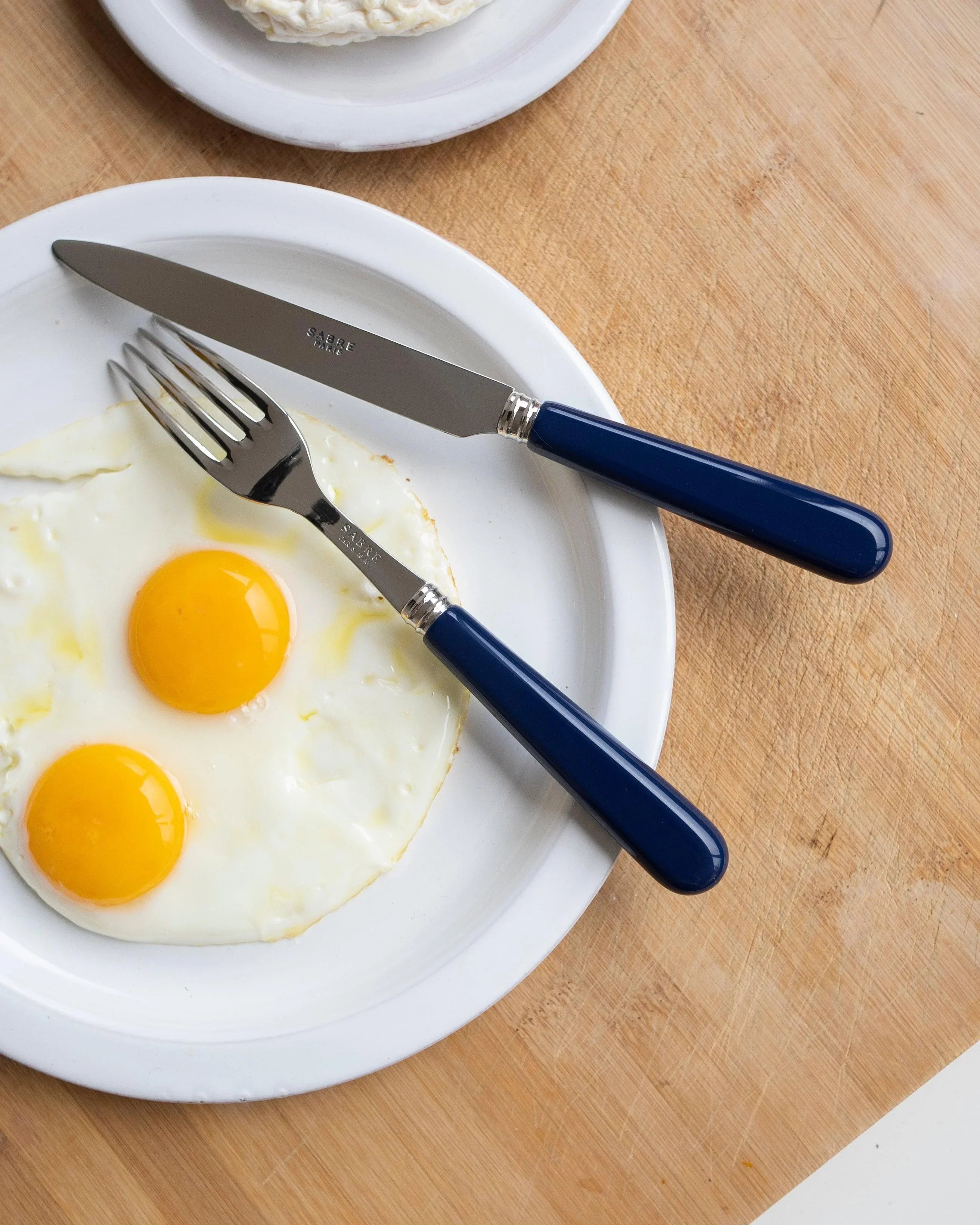 A plate with eggs and cutlery on it, part of the Navy Cutlery Set of 5 from Party Social.