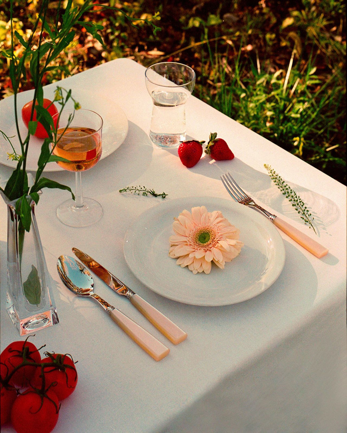 Pearl Cutlery Set of 5 on a table with a plate of food, glasses, and silverware, ideal for elegant gatherings.
