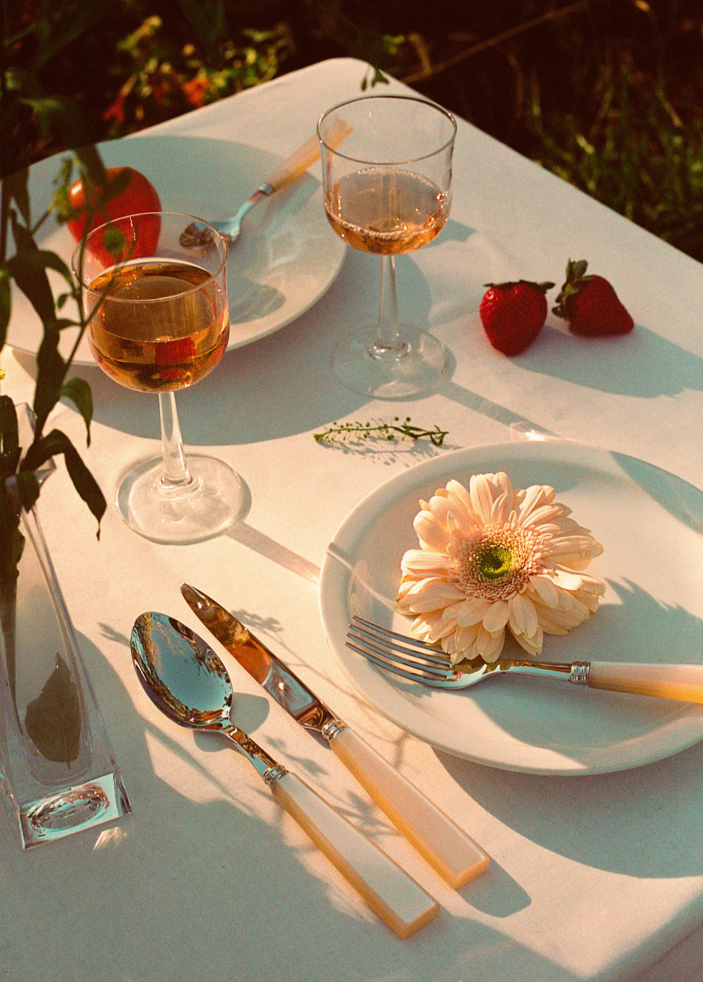 Pearl Cutlery Set of 5 on a table with a flower-adorned plate and a glass of wine, perfect for elegant events.