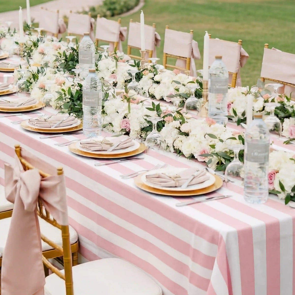 Pink Stripe Linen Tablecloth elegantly drapes a banquet table with gold chargers, pink sashes, and floral garland, set for a garden party.