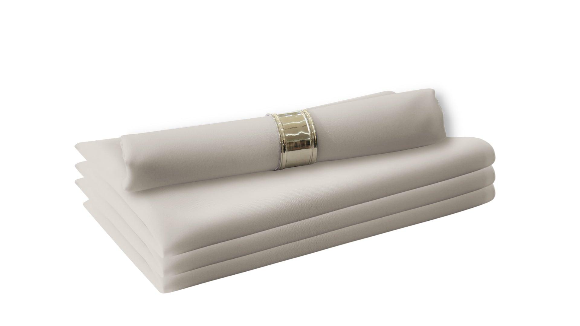 A stack of folded white polycotton napkins, perfect for livening up your dinner table. Easy to wash and reuse, these napkins are a staple in your dining table linens.
