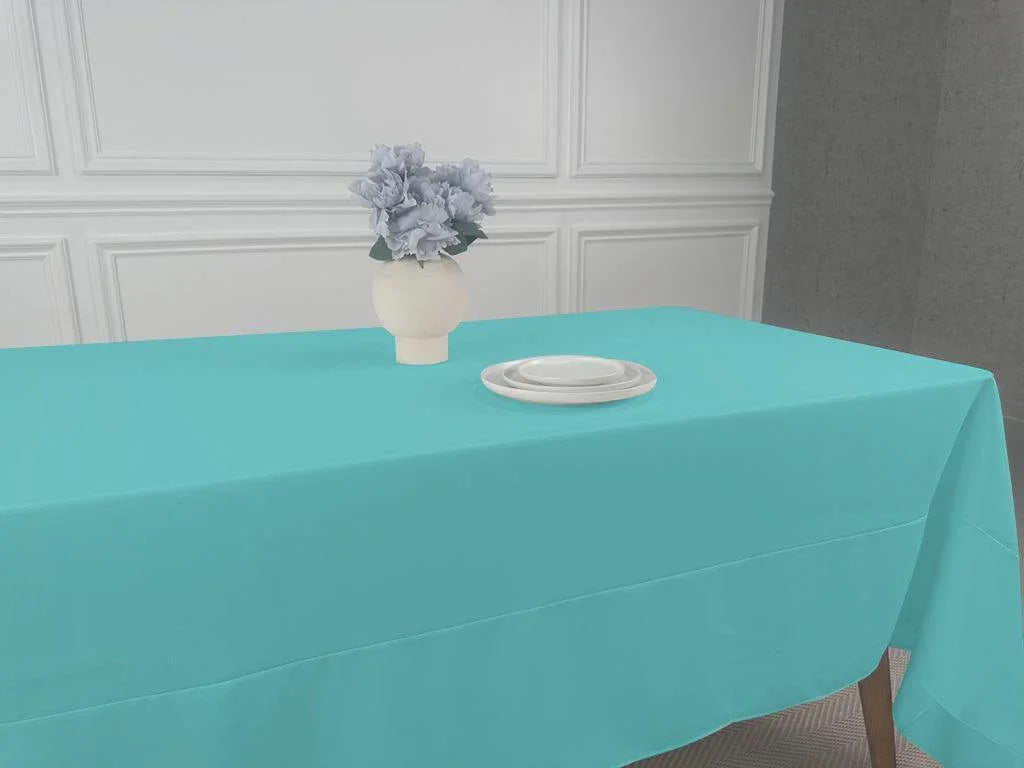 A Polycotton Tablecloth with a vase of flowers and white plates on it.