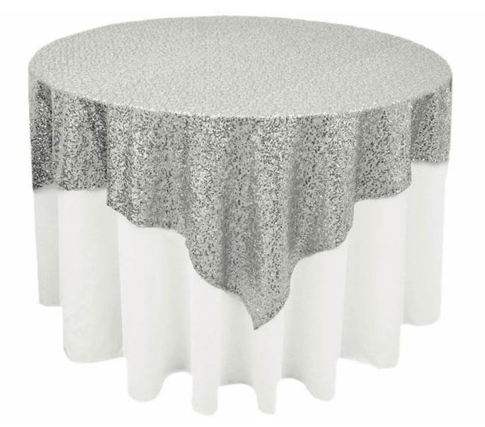 Sequin Overlay: A luxurious, silver sequin overlay elegantly draped over a round table, perfect for enhancing any party or special occasion setting.