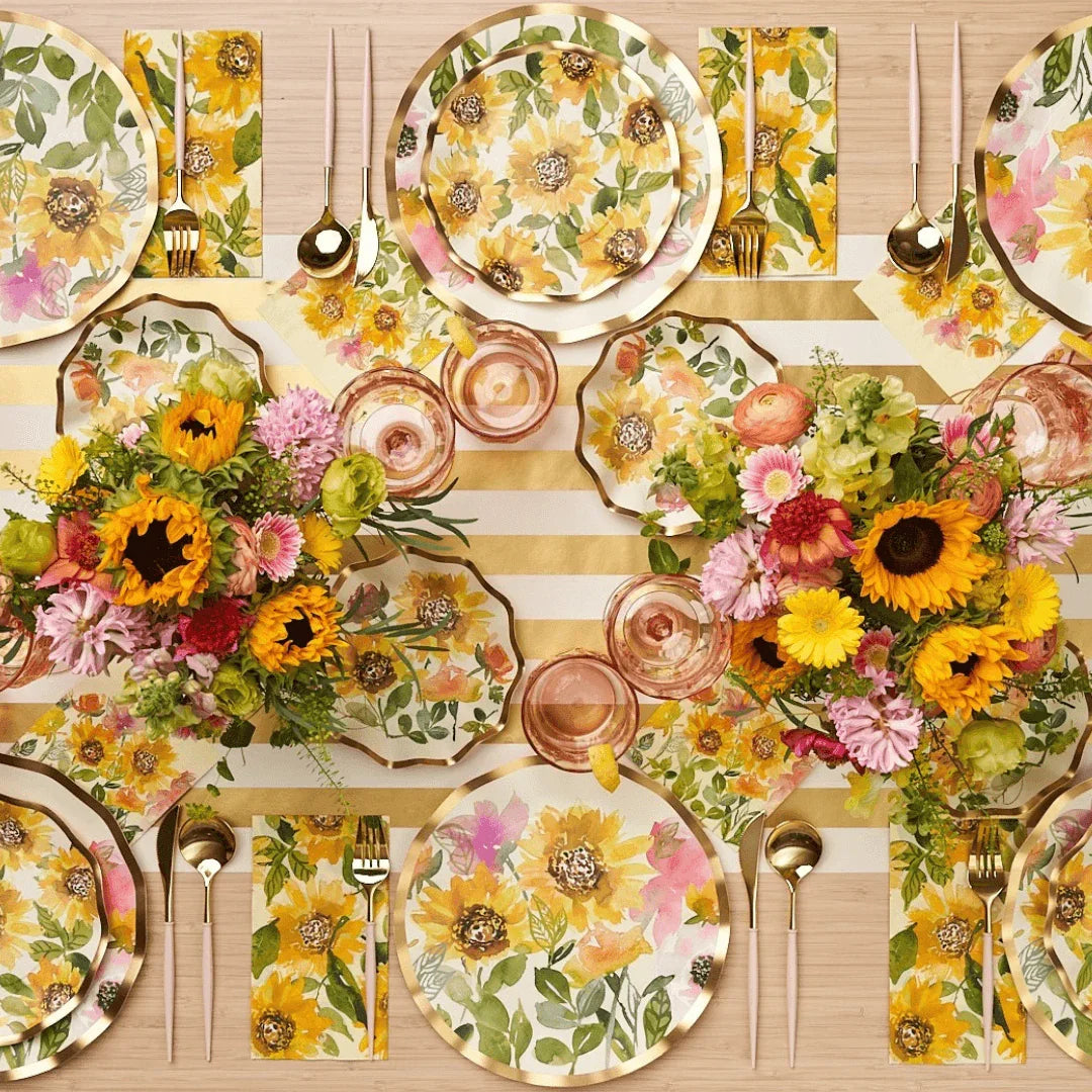Sunflower Paper Guest Towel Napkins on a table with floral plates and cut flowers, perfect for adding elegance to any party. 20 napkins per package.