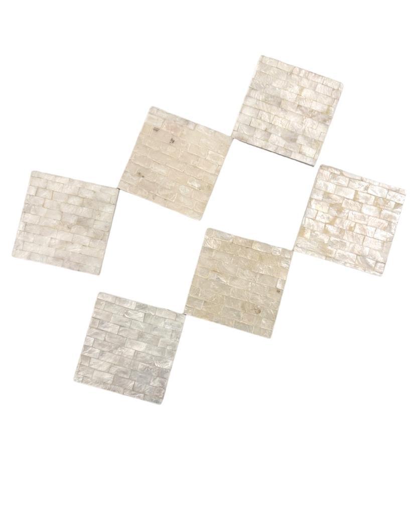 A set of premium white square tiles, featuring a close-up of a white brick. Perfect for adding a touch of elegance to your home and events. Coaster Seashells.
