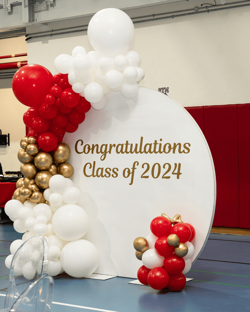 Graduation-themed sign featuring balloons and a festive banner for the graduate.