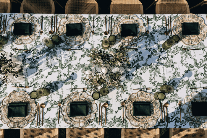 A beautifully arranged dinner table with green and white table cloths, ready for a delightful party.
