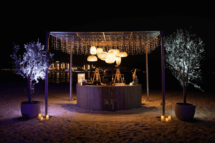 Beach chairs and umbrellas under the night sky, provided by Party Social Event Rentals Dubai.