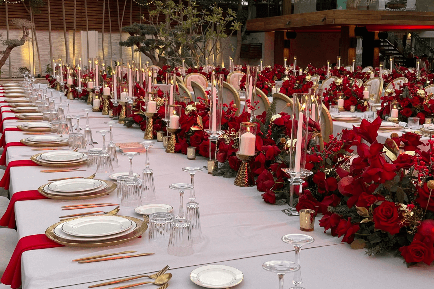 A long table adorned with red and white flowers, creating a beautiful and elegant centerpiece.