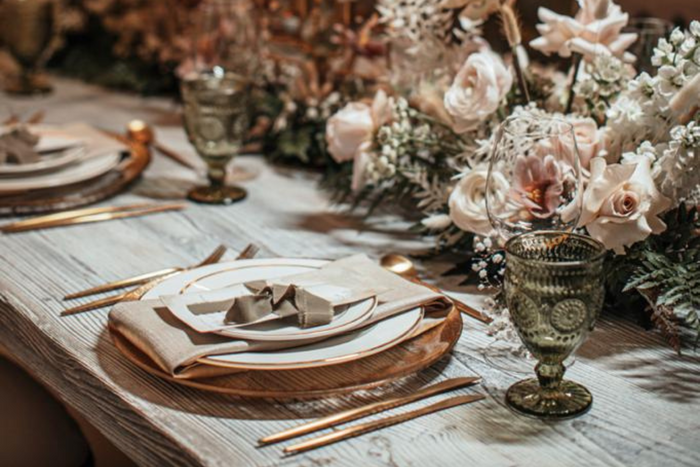 Elegant table setting adorned with gold and white flowers, showcasing sophistication by Party Social Event Rentals Dubai.