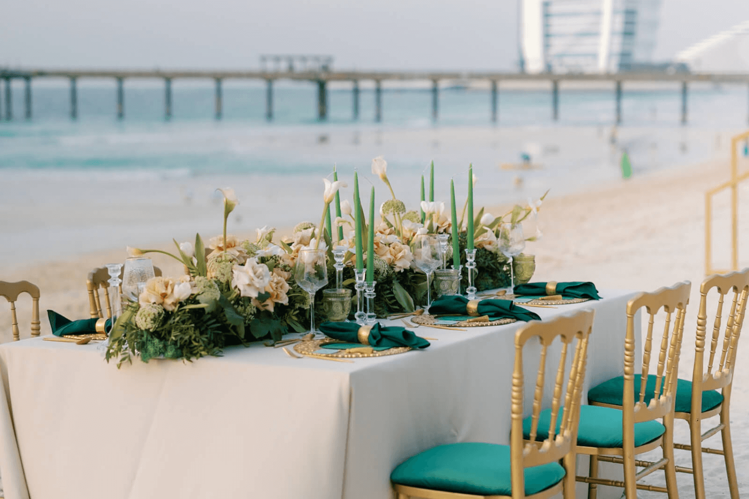 A beautifully arranged wedding table on the beach, adorned with elegant decor, by Party Social Dubai.