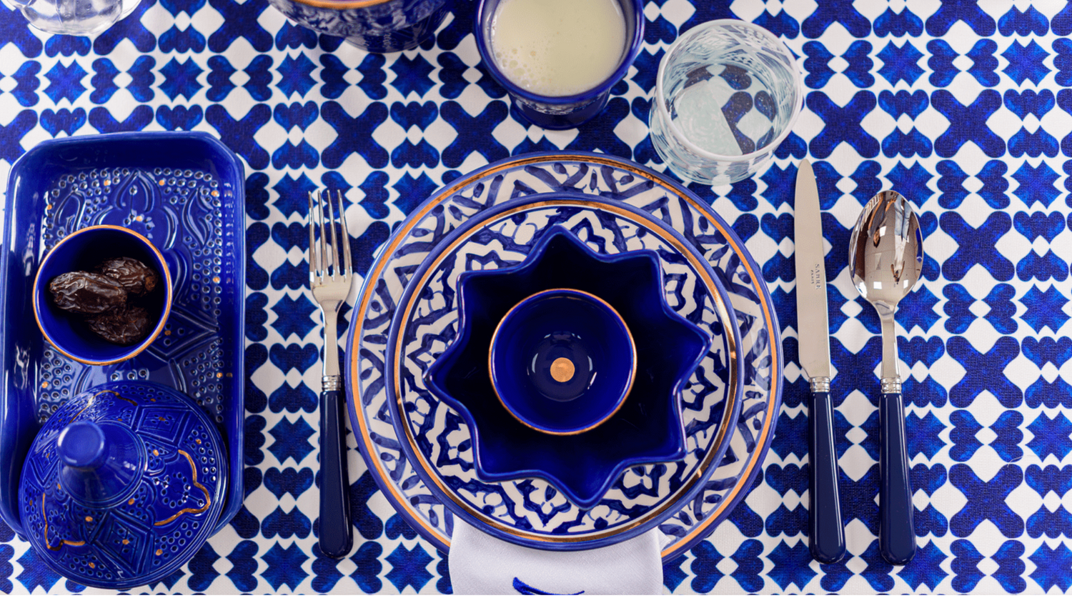 A blue and white ceramic table setting with plates, bowls, and cutlery, ideal for weddings, dinner parties, and special occasions.
