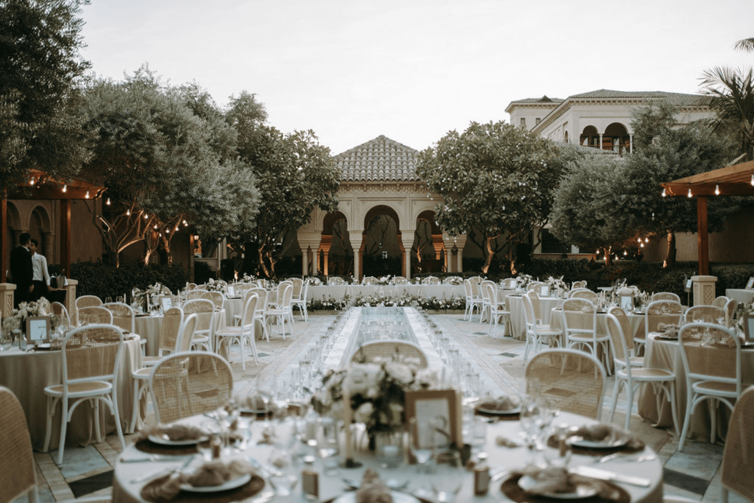 A set of elegant white plates and gold cutlery arranged on a table, suitable for weddings and special occasions from Party Social.
