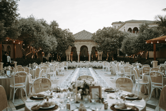 A set of elegant white plates and gold cutlery arranged on a table, suitable for weddings and special occasions from Party Social.