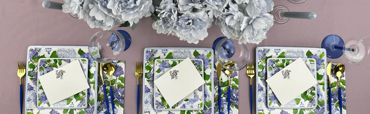 A table setting with flowers, a napkin, and a card, alongside close-ups of glasses and a blue pen.