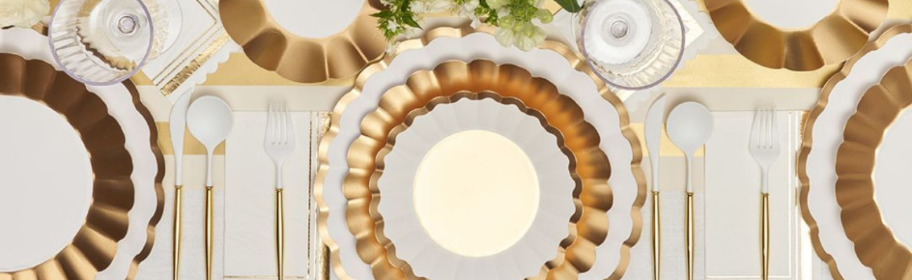 A stack of elegant plates with flowers, a gold and white candle holder, and a pen, ideal for party and event settings.