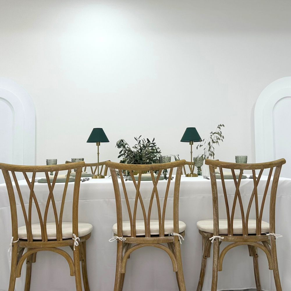 Serene Green- Dining Setup with a table, crisscross chairs, dinnerware, goblets, and green lamps for 8 guests, ideal for events and gatherings.