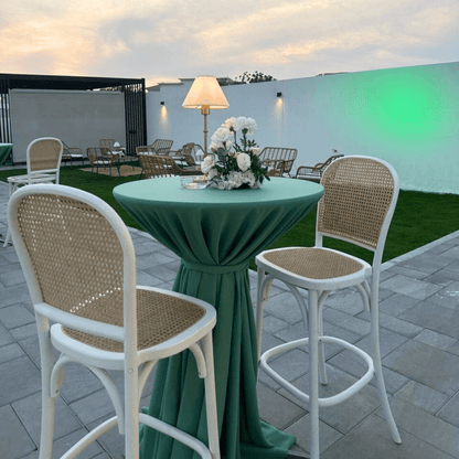 Sage Twilight-Cocktail Setup featuring a table for 8 with stools, flower centerpiece, and wireless lamp on a patio, ideal for events.