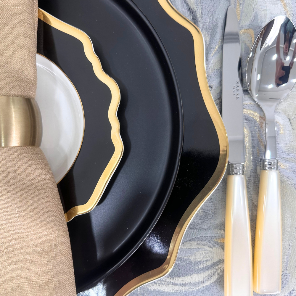 Opulent Twilight-Dining Setup featuring elegant black and gold plates with Sabre cutlery for eight guests, ideal for sophisticated dinner parties and events.